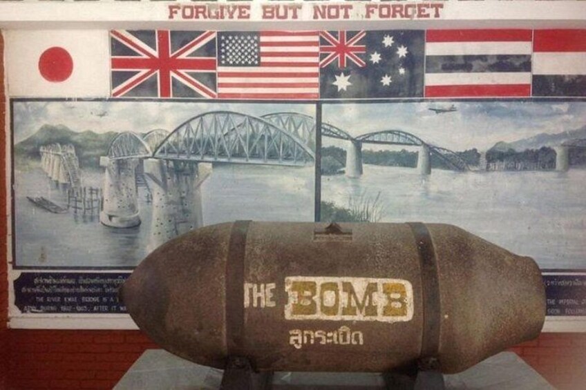 A bomb with 'THE BOMB' written on it, placed in front of a poster with multiple flags and a bridge. 3