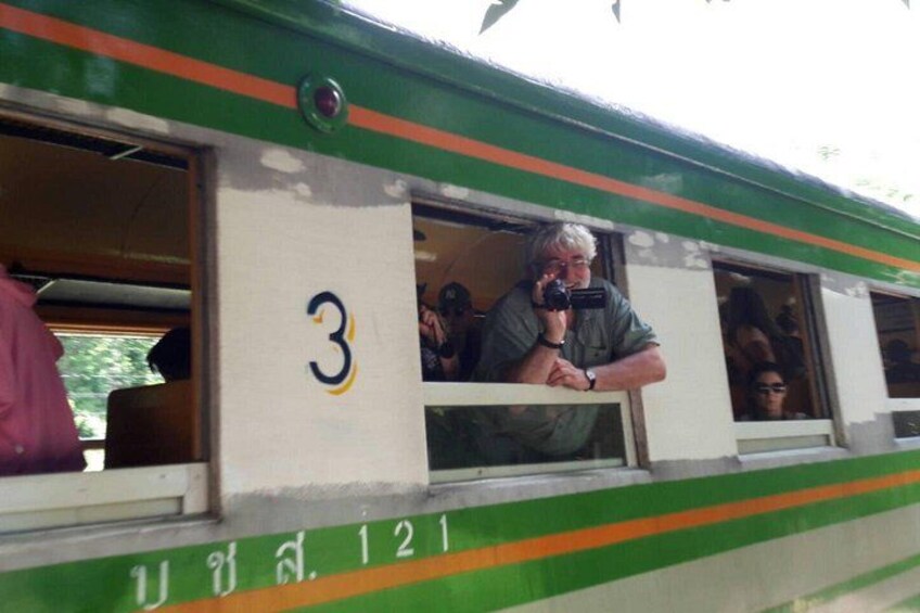 A train with the number 3 on its side, passengers inside, and a window with a reflection. 4