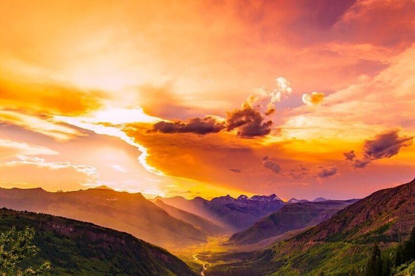 A mountainous landscape with a valley and a sunset. 3