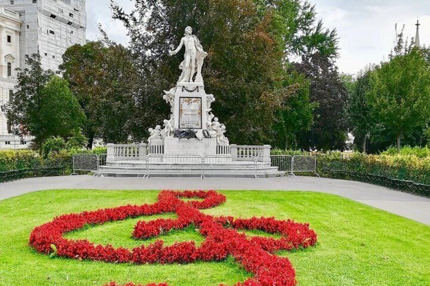 Een standbeeld in een park met rode bloemen in de vorm van een hart. 3