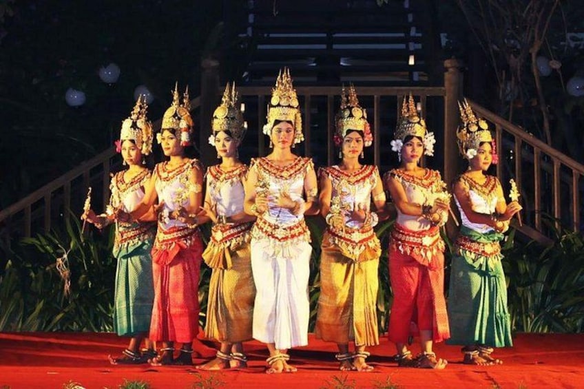 A group of people in traditional costumes standing on a stage with a staircase in the background. 5