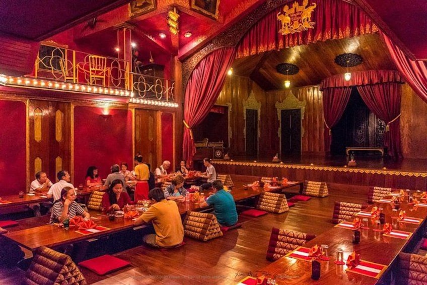 Ein Restaurant mit Holztischen und roten Vorhängen. 4