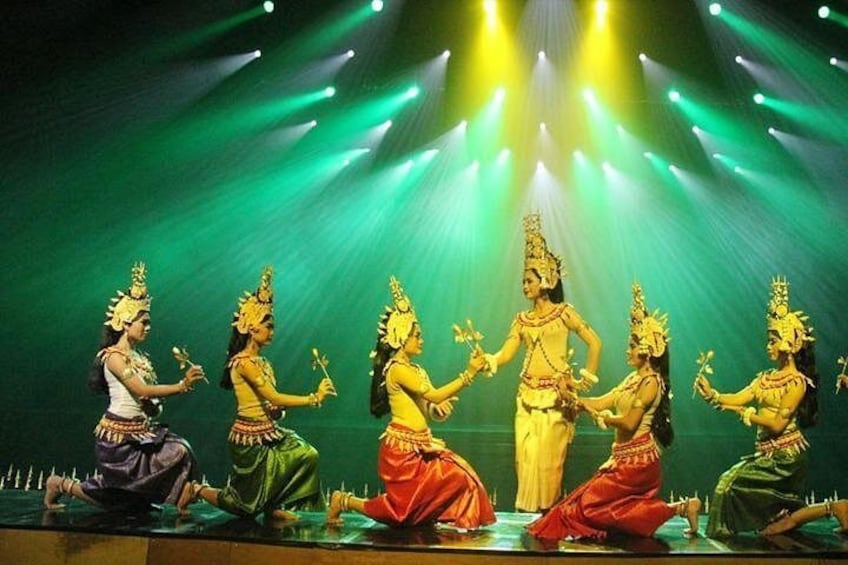 A group of dancers in traditional costumes performing on a stage with spotlights. 4