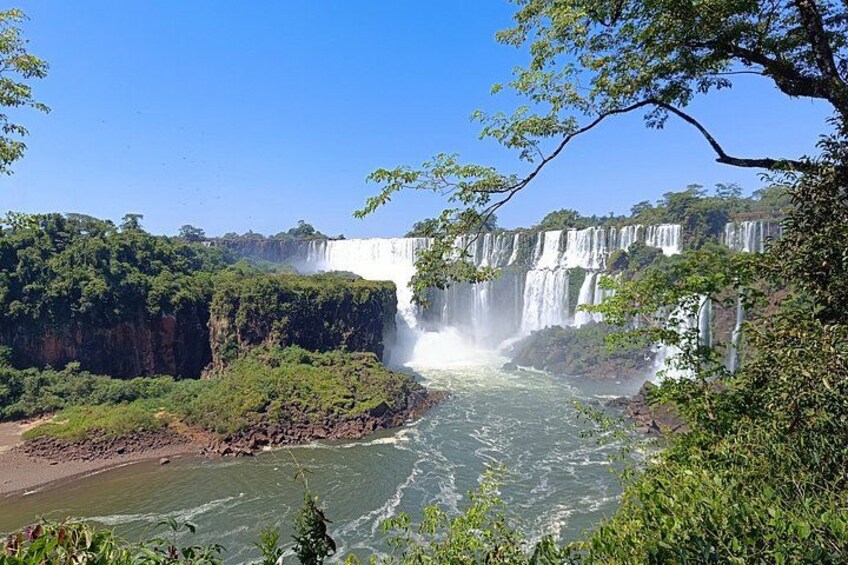 Una cascada fluye por un risco rodeado de exuberante vegetación. 5