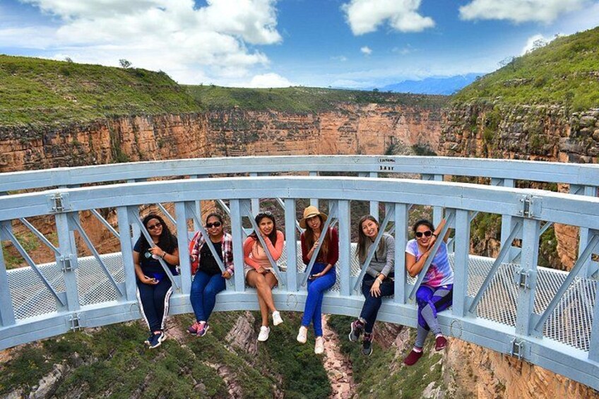 Eine Gruppe von Menschen auf einer Brücke mit Blick auf eine Schlucht. 5