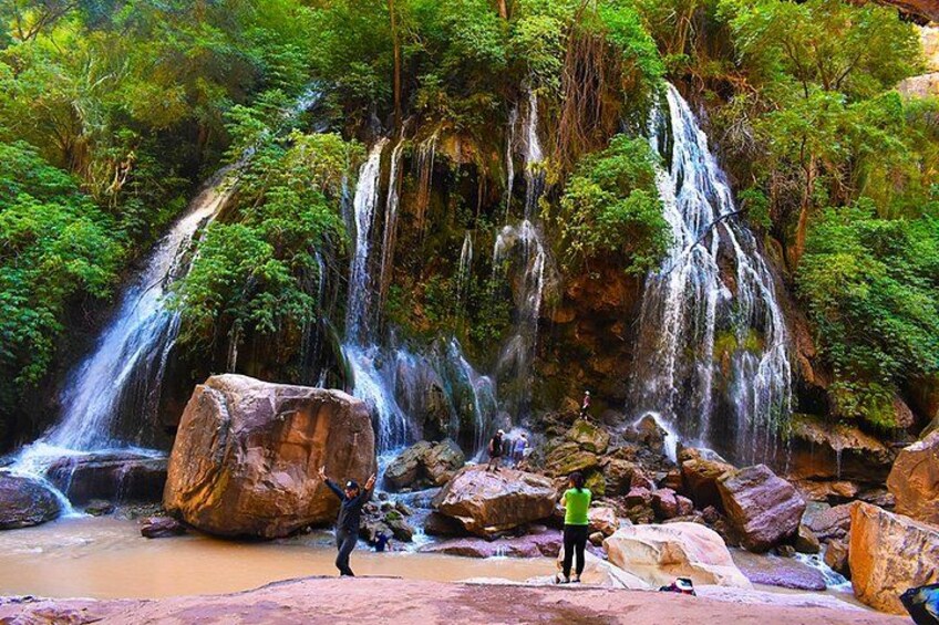 Ein Wasserfall, umgeben von Felsen und üppigem Grün. 2