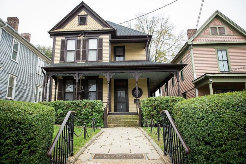 A two-story house with a porch, steps, and a mailbox. 4