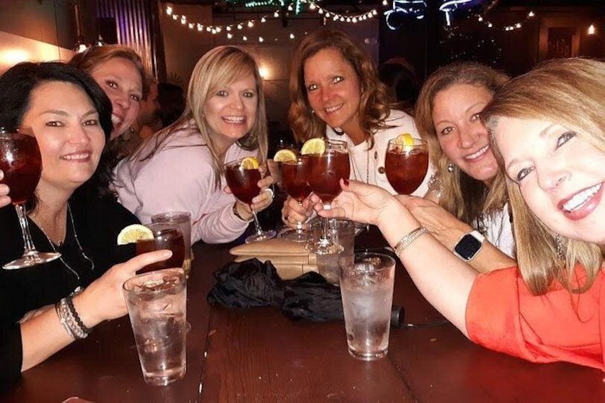 A group of people toasting with drinks at a table. 4