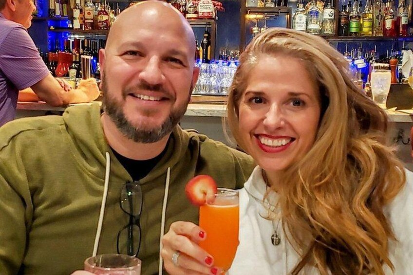 Twee personen zitten aan een bar met drankjes. 5