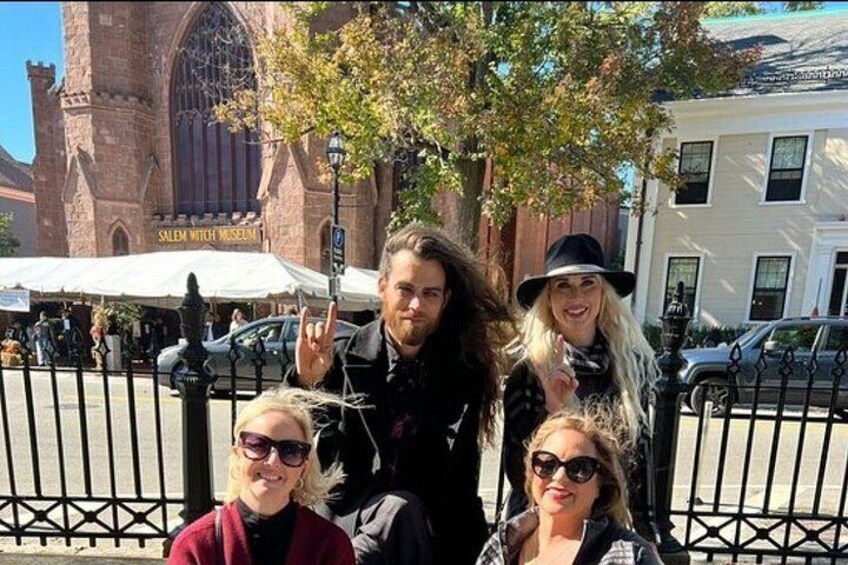 A group of people posing in front of a historic building with a sign that reads 'Salem Witch Museum.' 5