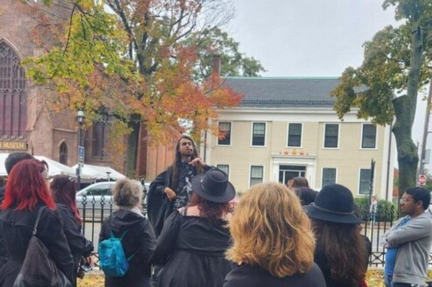A group of people gathered outdoors, a building with a sign that reads 'Museum,' and trees with autumn foliage. 2