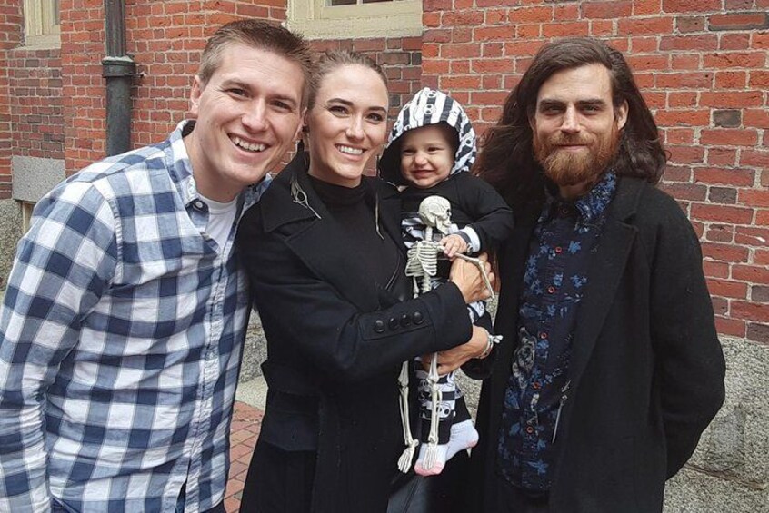 A family of four in front of a brick building. 4