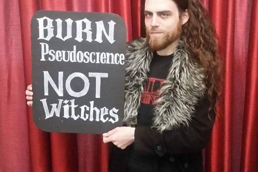 A person holding a sign that reads 'BURN Pseudoscience NOT Witches.' 3