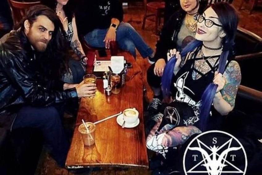 A group of people sitting at a wooden table with drinks and a menu. 4