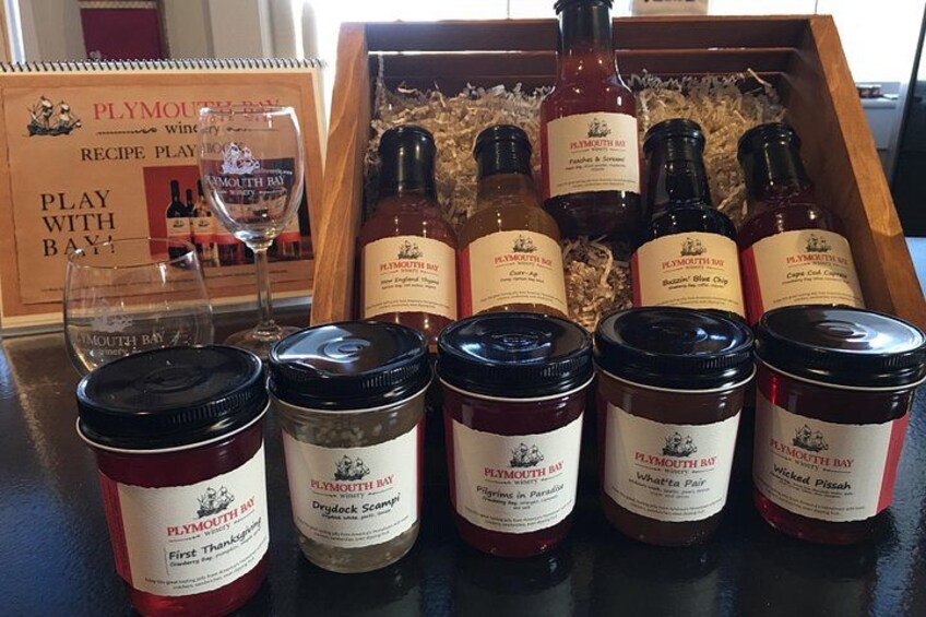 A wooden box containing Plymouth Bay products, including bottles and jars of various sauces and condiments. 1
