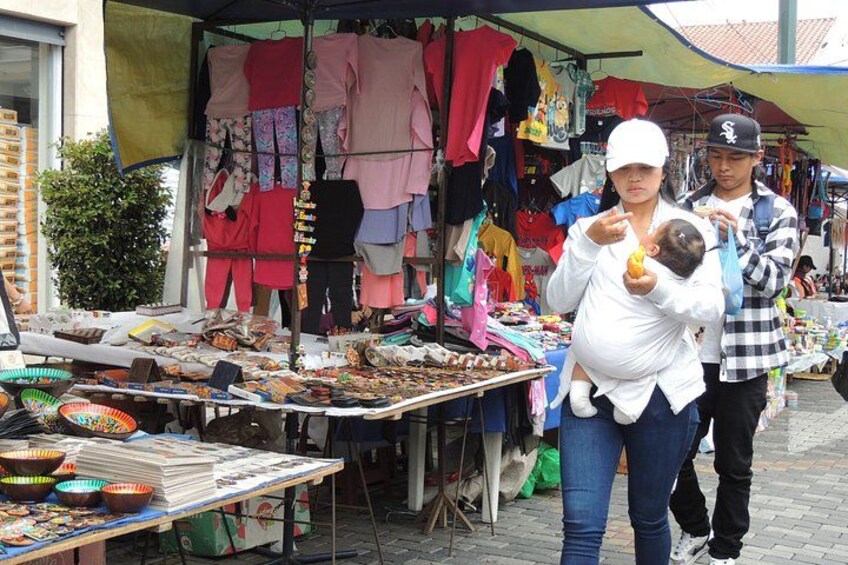 Een straatmarkt met kraampjes waar kleding en accessoires worden verkocht. 2