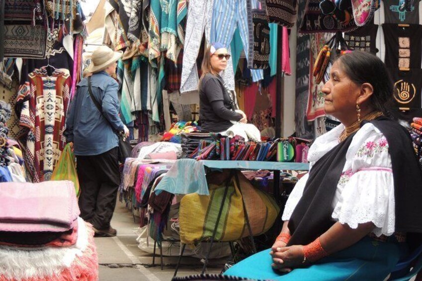 Een markt met kleurrijke textielwaren en een persoon in traditionele kleding. 2