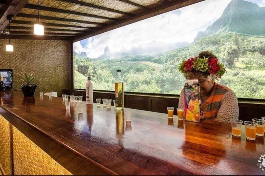 Un bar con mostrador de madera, vasos y una botella. 4
