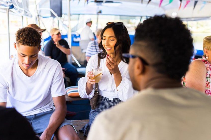 People sitting on a bus, some holding drinks. 4