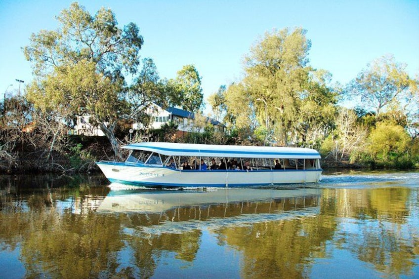A boat with passengers, surrounded by trees and houses along a calm river. 3