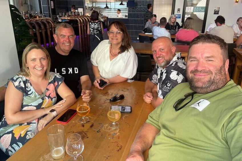 A group of people sitting at a wooden table in a restaurant. 3