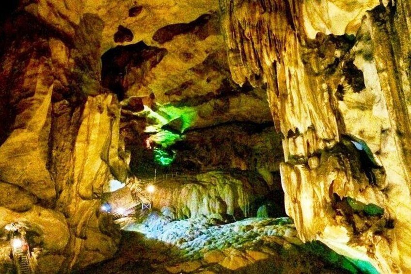 A cave with stalactites and stalagmites, illuminated by artificial lighting. 5