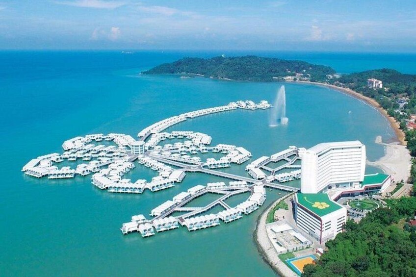 An aerial view of a coastal resort with a heart-shaped marina, a fountain, and a large hotel. 4
