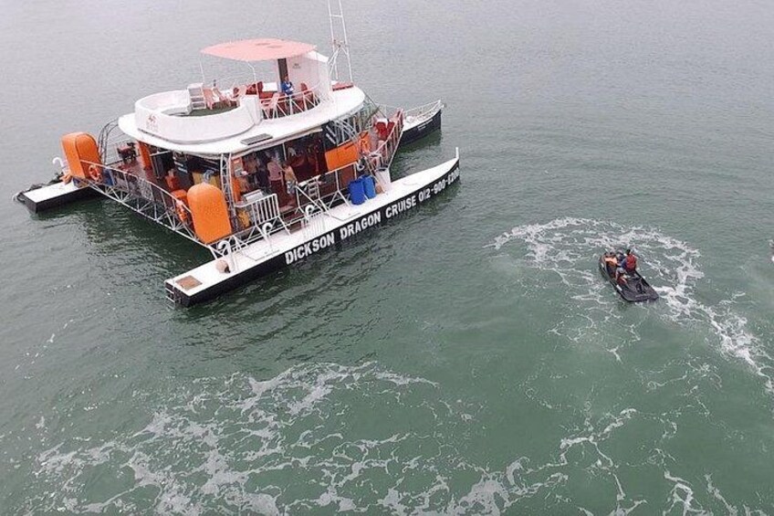 A boat named 'Dickson Dragon' with a person in a small motorboat nearby. 5