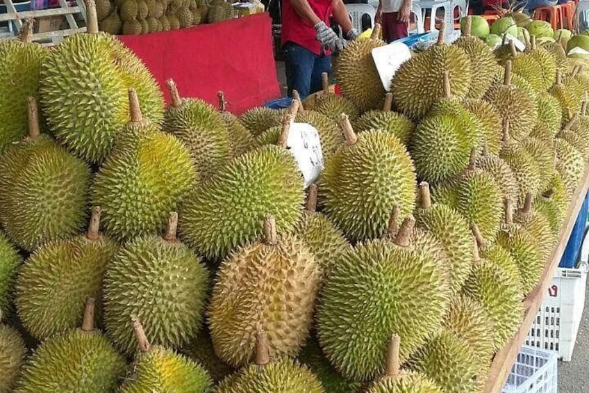 A market stall with durians displayed on a table. 4