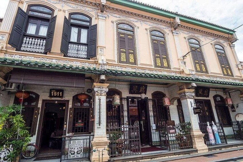 Un edificio histórico con detalles arquitectónicos ornamentales, incluyendo múltiples ventanas con contraventanas y el número '1511' destacado en la fachada. 5