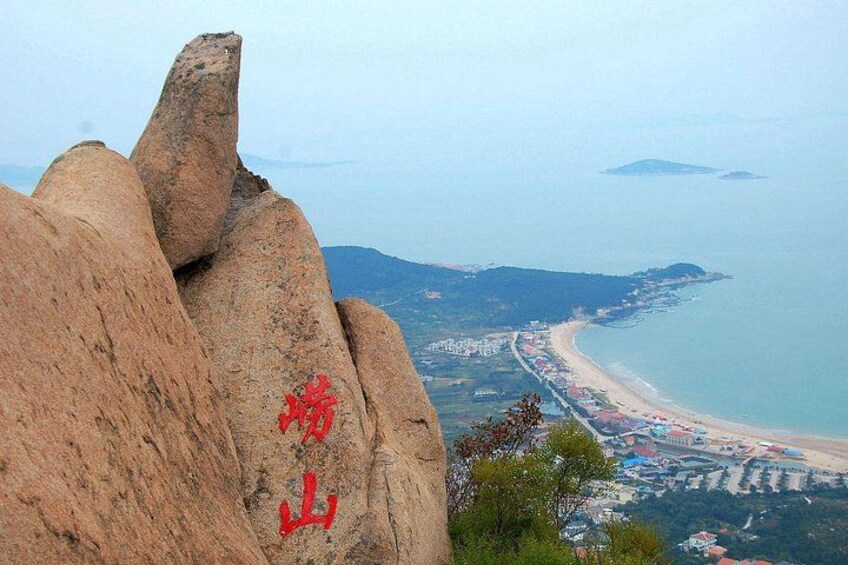 A coastal landscape with a prominent rock formation and a beach. 3