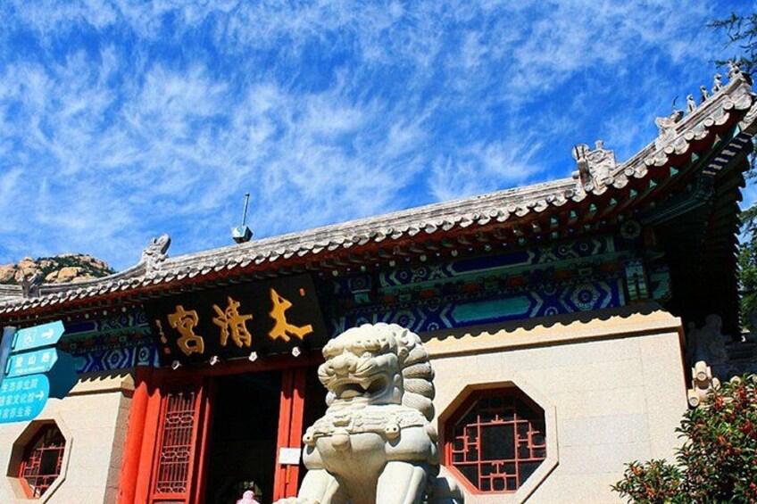 A traditional building with a lion statue in front, a tiled roof, and a sign with Chinese characters. 5