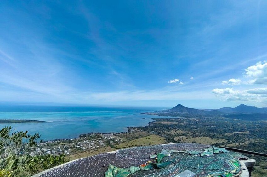 Un paysage côtier comprenant une montagne, une plage et une structure à motifs au premier plan. 2