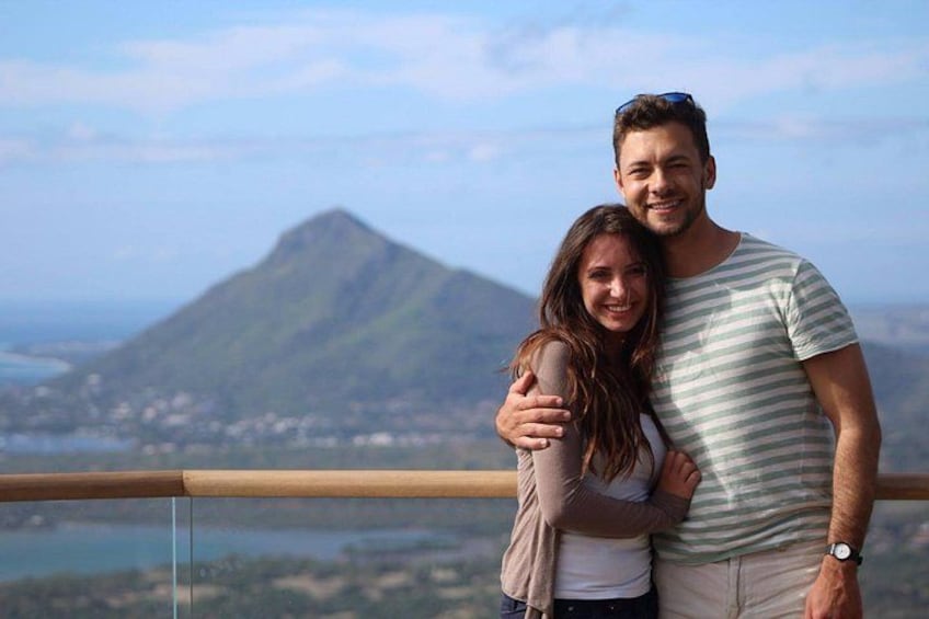 Un couple s’embrasse, avec un paysage montagneux en arrière-plan. 1