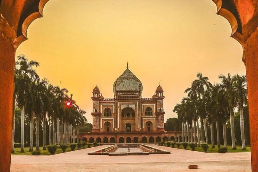 A large, ornate building with a dome and multiple towers, surrounded by a symmetrical arrangement of palm trees. 4