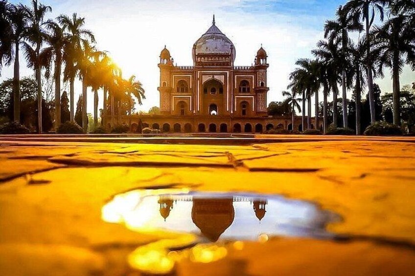 A large, ornate building with a dome and arches, surrounded by palm trees. 2