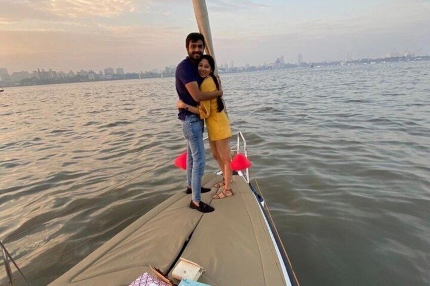 A couple standing on a boat with a city skyline in the background. 5