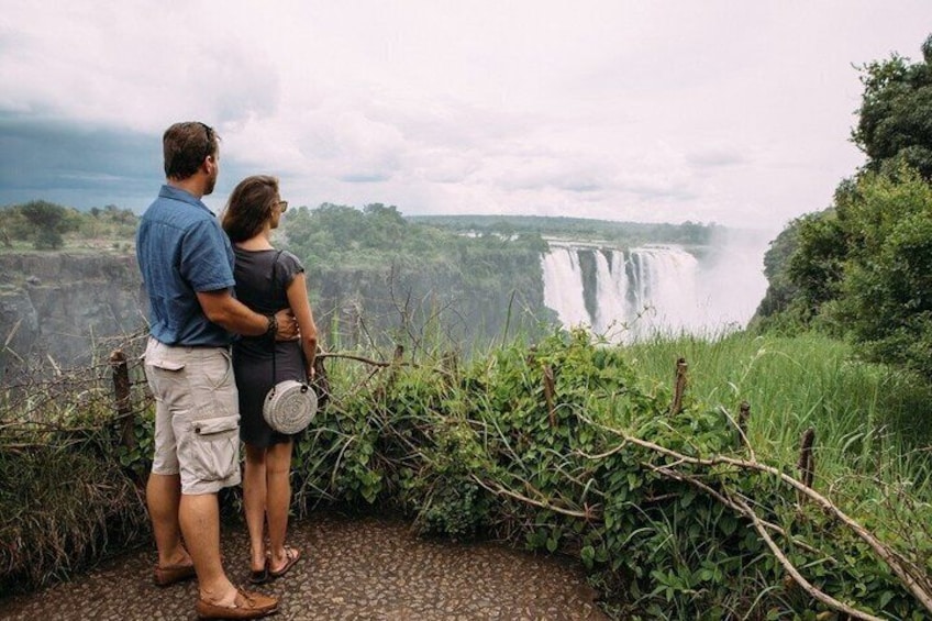 A couple standing by a waterfall. 3