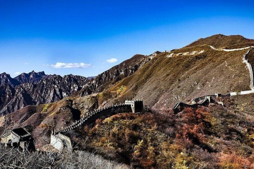 A mountainous landscape with a stone bridge and a road winding through it. 2