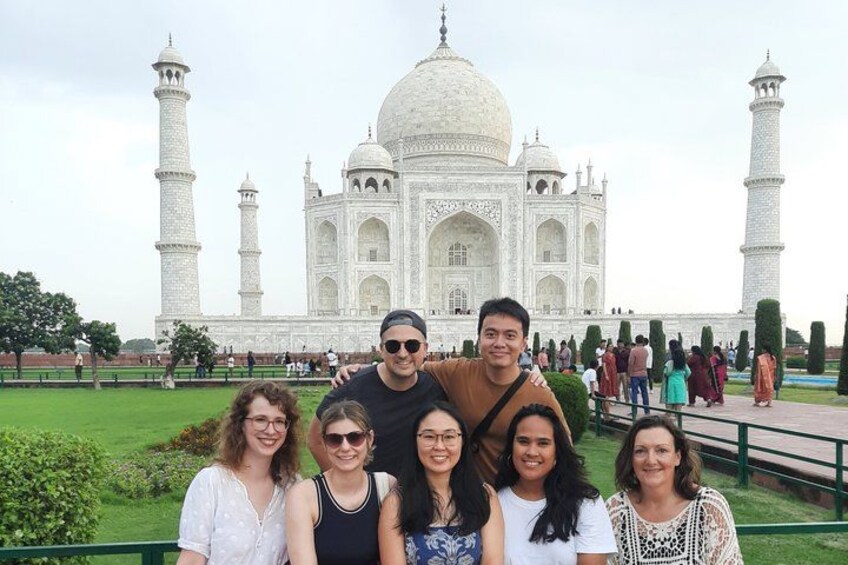 Un grupo de personas frente al Taj Mahal, con sus cuatro minaretes y gran cúpula. 5