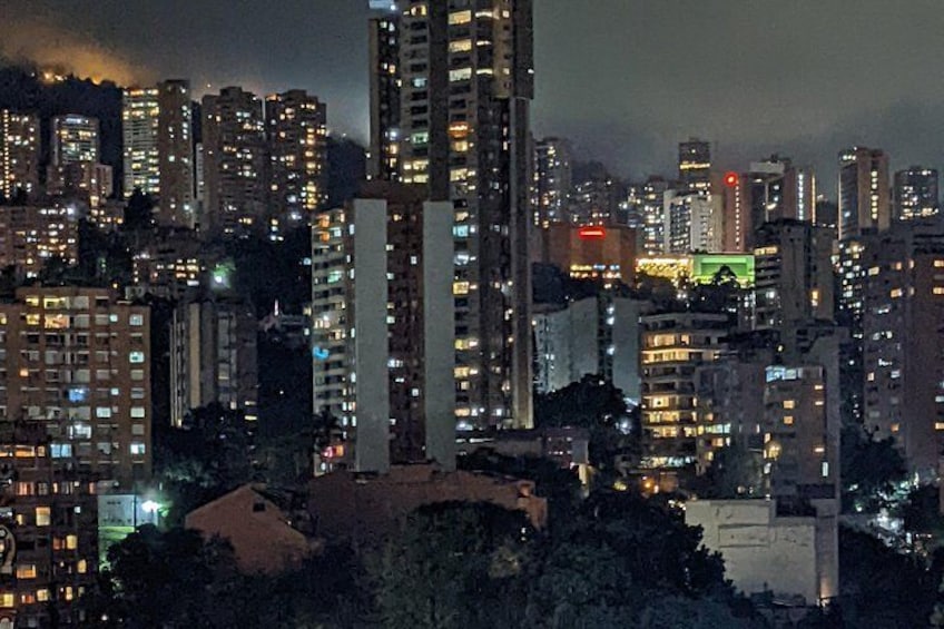 A nighttime cityscape with high-rise buildings and illuminated windows. 4