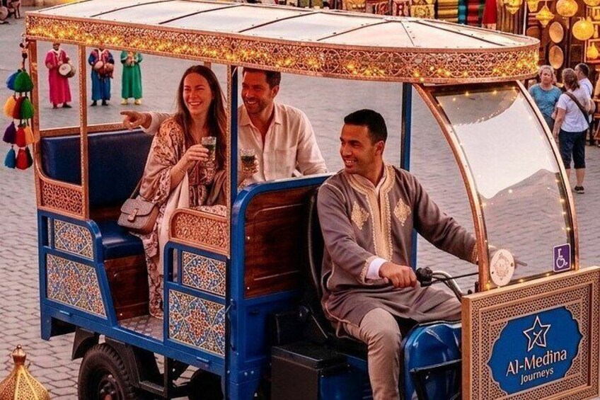 A traditional rickshaw with intricate designs, passengers inside, and a sign for Al-Madina Journeys. 5