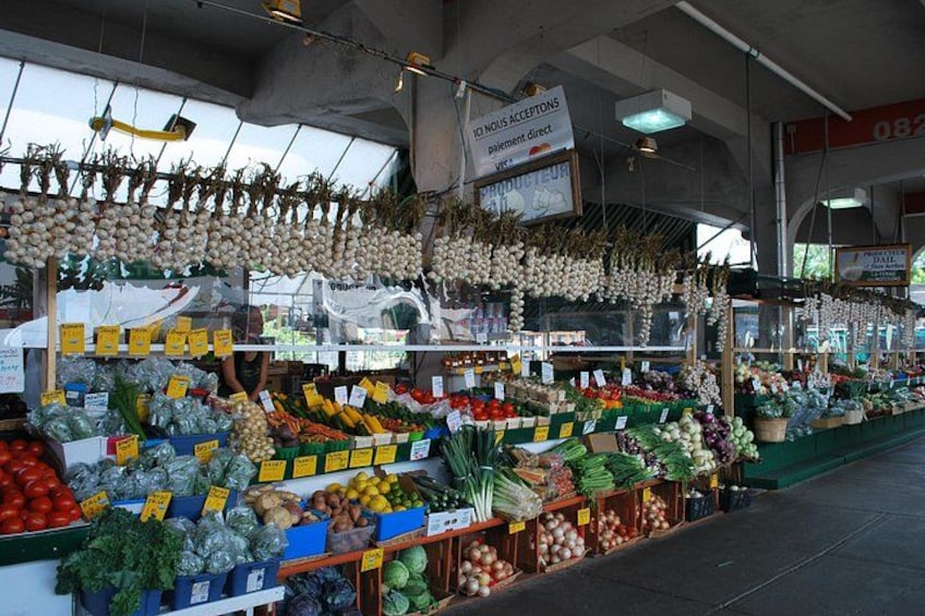 Un mercado con diversos vegetales expuestos, como tomates, cebollas y verduras de hoja. 4