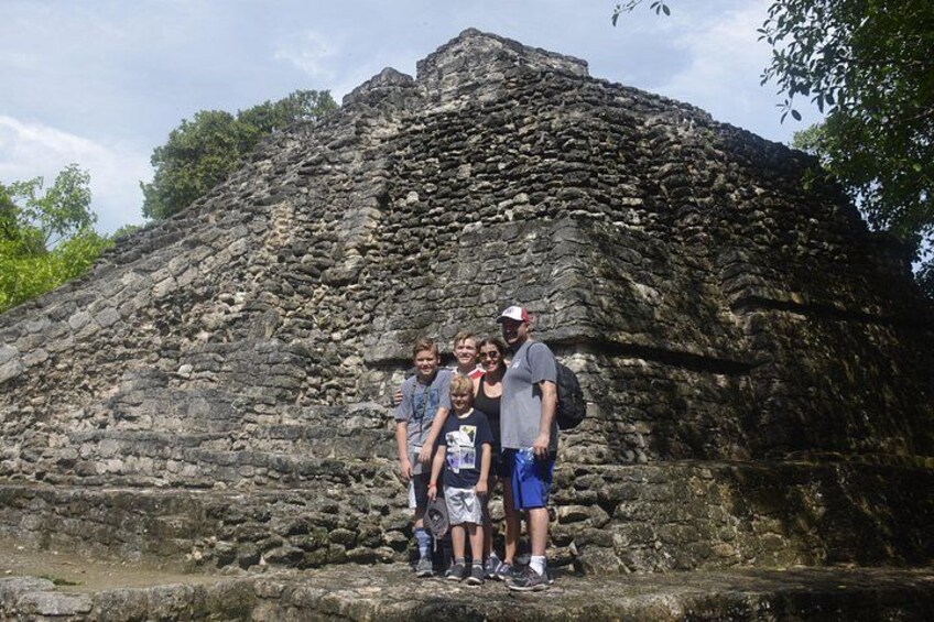 Een groep mensen staat voor een grote piramide van steen. 5