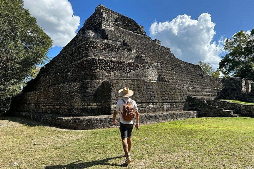 Una persona caminando hacia una gran estructura de piedra antigua. 1