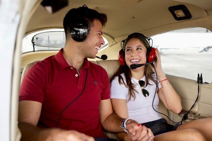 Deux personnes sont assises dans le cockpit d’un petit avion, et portent toutes les deux un casque. 2