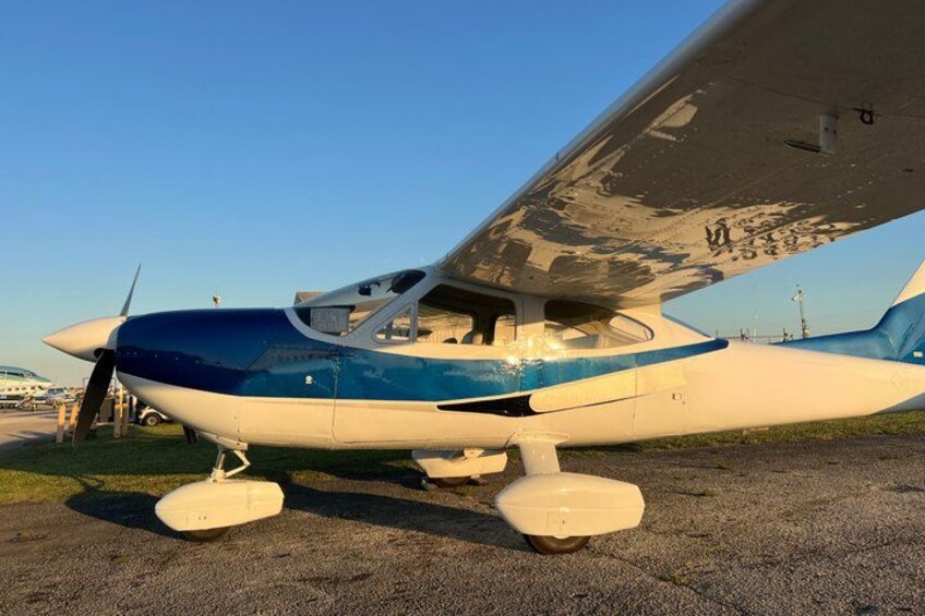 Un piccolo aeromobile parcheggiato sul piazzale con un cielo sereno sullo sfondo. 4