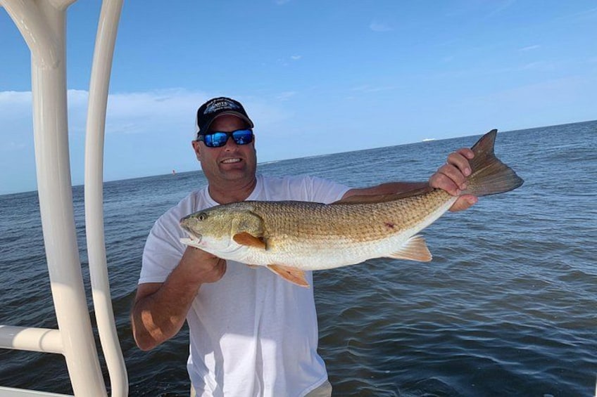 A person holding a fish on a boat. 2