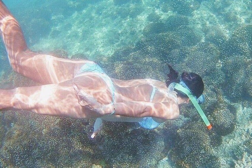 Eine Person mit Schnorchel und Flossen beim Schnorcheln unter Wasser. 4
