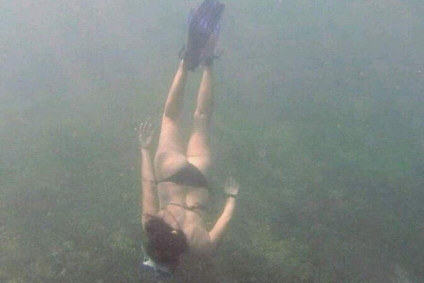 Eine Person im Wasser, mit Badeanzug und Flossen. 5